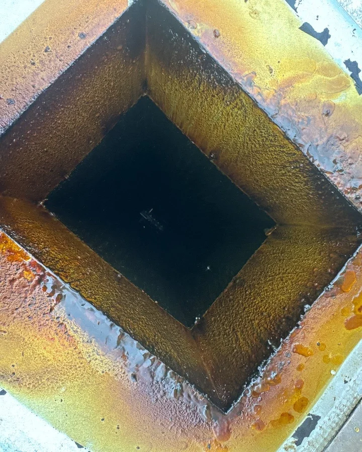Grease duct access with heavy grease buildup before cleaning